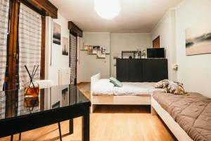 ein Wohnzimmer mit einem Sofa und einem Glastisch in der Unterkunft Appartamento Castelli - Affitti Brevi Italia in Varese
