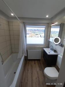 a bathroom with a tub and a toilet and a sink at Apartment Feldkirch in Feldkirch