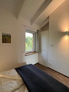 a bedroom with a large bed and a window at Ferienhaus Auszeit mit Sauna in Schwarz