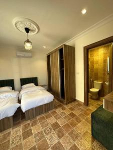 a hotel room with two beds and a bathroom at 5/ Antica jabalal-lwebdeh in Amman