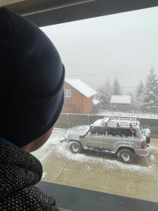 Una persona che guarda fuori dalla finestra un'auto nella neve di Буков'ян a Ilʼtsya Gurny