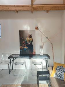 uma mesa numa sala de estar com um quadro na parede em Boutique appartement vlak bij Amsterdam em Rijnsaterwoude