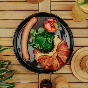 a plate of food with a hot dog and vegetables at Apartmány J&J in Šumperk