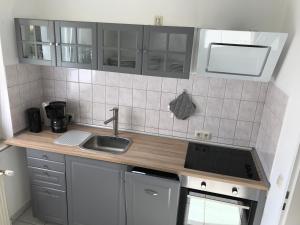 a small kitchen with a sink and a stove at Strandnahes Ostsee Apartment Malum in Zierow