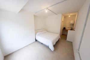 Petit apart في فيلا ماريا: غرفة نوم بيضاء صغيرة فيها سرير