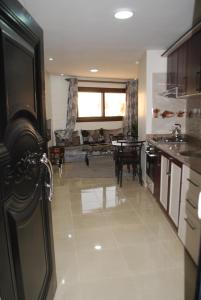 eine Küche mit einem Wohnzimmer mit einem Tisch und einem Sofa in der Unterkunft Apartamentos Bchraya in El Aaiún