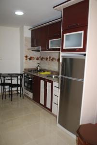 a kitchen with a stainless steel refrigerator and a table at Apartamentos Bchraya in Laayoune