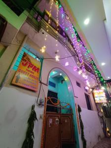 Um edifício com luzes de Natal e um cartaz. em JPM GUEST HOUSE em Varanasi