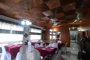 um salão de banquetes com mesas vermelhas e cadeiras brancas em CHANA BRICKS BUNGALOW em Ratnapura