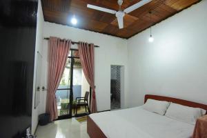 um quarto com uma cama branca e uma janela em CHANA BRICKS BUNGALOW em Ratnapura