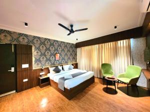 a bedroom with a bed and a ceiling fan at Hotel Royal Plaza in Srinagar