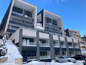 an apartment building with snow in front of it at Sarajevo 84 in Bjelašnica