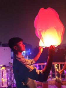 um homem segurando uma lanterna à noite em JPM GUEST HOUSE em Varanasi mais 77 fotografias