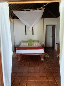 Bett in einem Zimmer mit weißem Baldachin in der Unterkunft nosykombafafa 