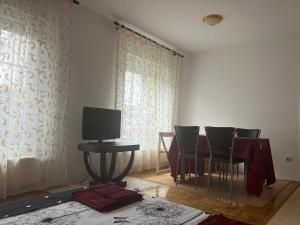 een kamer met een tafel en stoelen en een televisie bij Margita Apartment in Belgrado