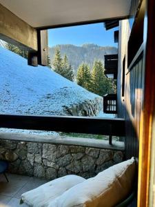 a view of a snow covered mountain from a window at Le LihamWood in Megève
