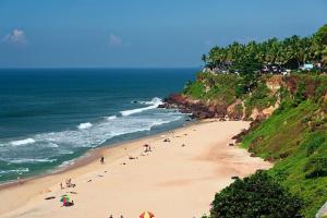 a group of people on a beach near the ocean at Grand Residency & Resort in Varkala