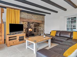 a living room with a couch and a television at Morfa Ganol in Llangranog