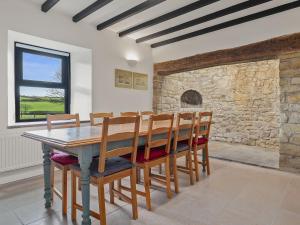 a dining room with a wooden table and chairs at Morfa Ganol in Llangranog