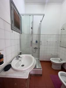 a bathroom with a sink and a shower and a toilet at J Nova LDA in São Tomé