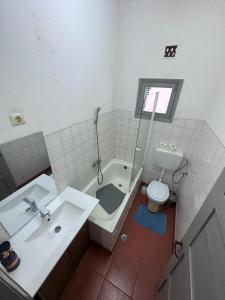 a bathroom with a tub and a sink and a toilet at J Nova LDA in São Tomé