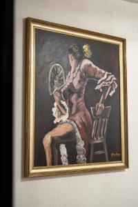 uma pintura de uma mulher sentada numa cadeira em Hotel Restaurant Domestika em Skopje