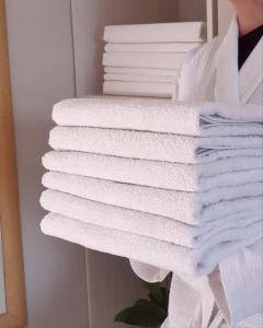 einen Stapel weißer Handtücher auf einem Regal in der Unterkunft Sky hotel KG in Bischkek