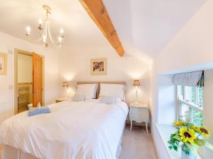 Un dormitorio con una gran cama blanca y una ventana en Graydon Cottage, en Wigglesworth