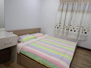 Best Sekinchan homestay في سيكينتشان: غرفة نوم صغيرة بها سرير ونافذة