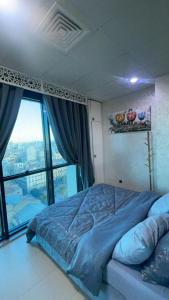 a bedroom with a bed and a large window at Luxe Studio Sea View in Oran