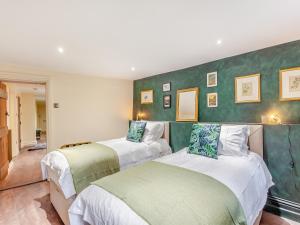 2 Betten in einem Zimmer mit grünen Wänden in der Unterkunft The Garden Flat in Bath