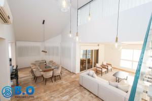 sala de estar con sofá, mesa y sillas en על הים, en Netanya