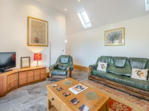 a living room with a couch and a tv at The Old Greenhouse - Uk45328 in East Barkwith