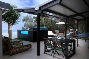 a patio with a table and chairs and a grill at Vistas Del Valle; piscina, wifi bbq... in Santa Cruz de Tenerife