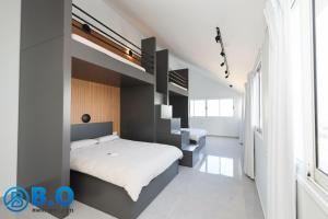 1 dormitorio con 2 camas y escalera en על הים, en Netanya
