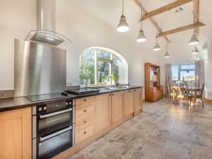 a kitchen with wooden cabinets and a stove top oven at The Old Greenhouse - Uk45328 in East Barkwith