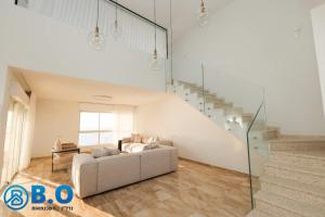 a living room with a couch and a staircase at על הים in Netanya +24 photos