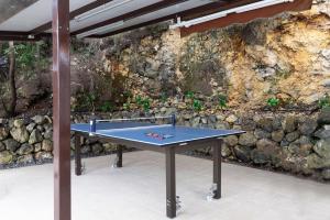 a ping pong table in front of a stone wall at Vistas Del Valle; piscina, wifi bbq... in Santa Cruz de Tenerife