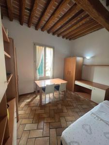 Cette chambre comprend une table, des chaises et un lit. dans l'établissement Appartamento Saragozza, à Bologne