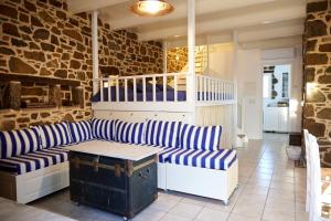 a living room with a blue and white striped couch at Aspros Pyrgos in Volissos