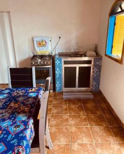 eine Küche mit Herd und ein Bett in einem Zimmer in der Unterkunft Meu aconchego caiçara in Paraty