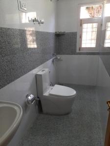 y baño con aseo blanco y lavamanos. en Sunrise homestay, en Kīar