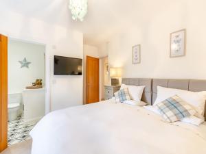 a bedroom with a large white bed with pillows at Adair Cottage in Wigglesworth