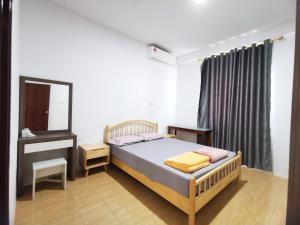 Schlafzimmer mit einem Bett, einer Kommode und einem Spiegel in der Unterkunft pen kyu house2 