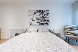 a bedroom with a large bed and two chairs at Stunning Luxury 2 Bedroom London Apartment in London