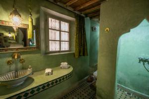 ein Bad mit einem Waschbecken und einem Spiegel in der Unterkunft Riad Les Idrissides in Fès