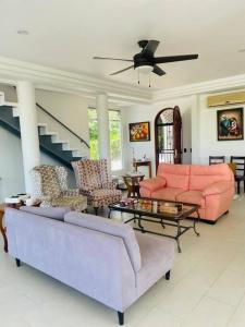 una sala de estar con muebles de color rosa y una escalera. en Cozy family house with pool, en Atenas