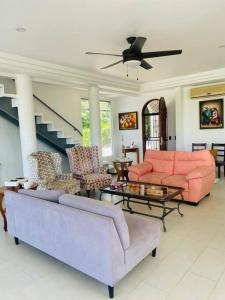 a living room with pink furniture and a staircase at Cozy family house with pool in Atenas