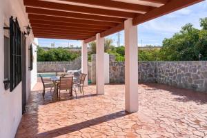 a patio with a table and chairs and a stone wall at La casita de Sergio in Frigiliana