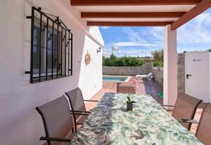 a patio with a table and chairs and a pool at La casita de Sergio in Frigiliana